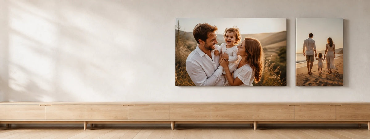 A family photograph on a large gallery-wrapped canvas beside a beach canvas, above an oak sideboard